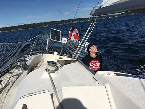 Andrew at the helm, checks the trim.