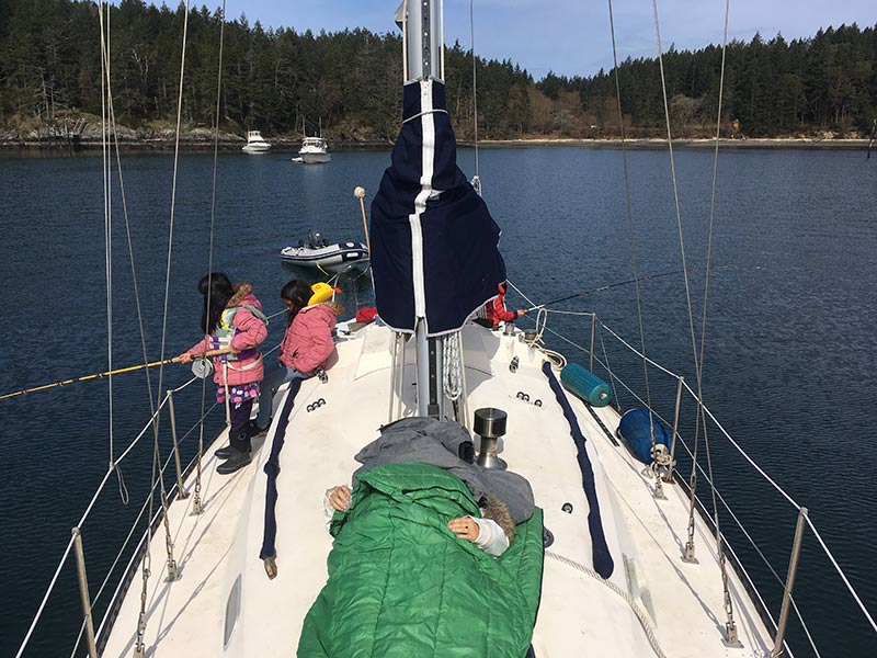 Under the watchful eye of their mother, the children take turns fishing.