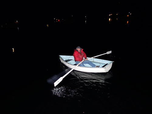 Kevin on his way to the dock to retrieve Eric is illuminated by the ships spotlight.