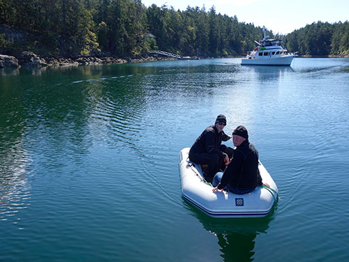 Eric and Kevin returning from the dinghy dock in Princess Cove. The nude sunbathing dock is seen in the background.