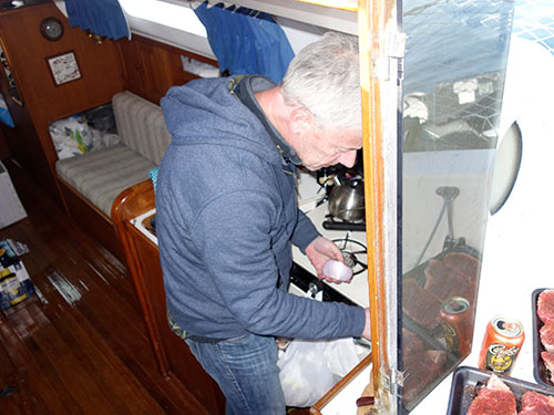 Paul mans the galley while the steaks are ready for the grill.